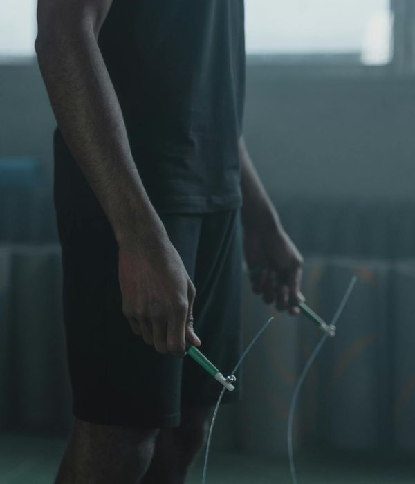 Man performing a controlled strength exercise in a dark modern gym.